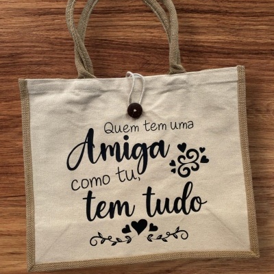 Sacola de tecido bege com texto preto e alças em tecido marrom