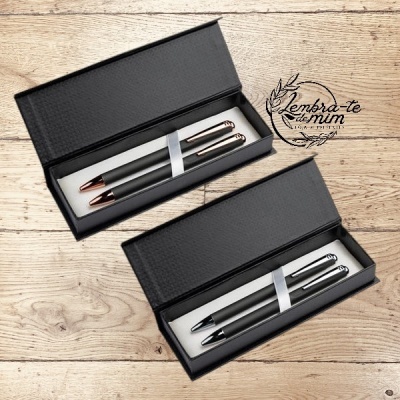 Conjuntos de canetas pretas com detalhes metálicos em caixas pretas sobre mesa de madeira