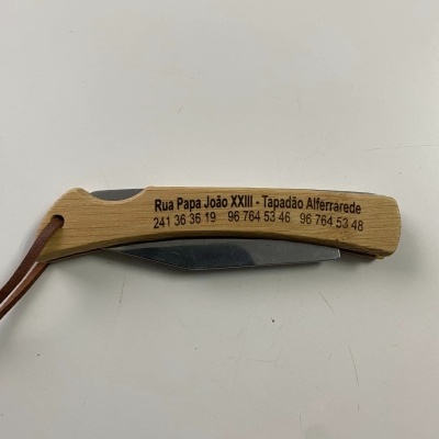 Canivete de cabo de madeira com texto gravado e lâmina de metal fechada