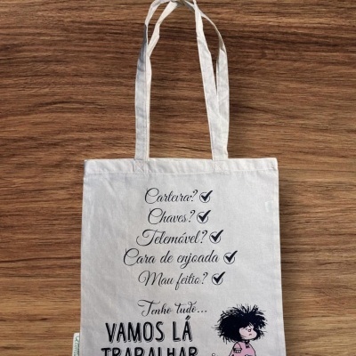 Saco de tecido creme com alças e texto impresso a preto com ilustração