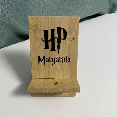 Suporte de telemóvel em madeira clara com texto HP Margarida