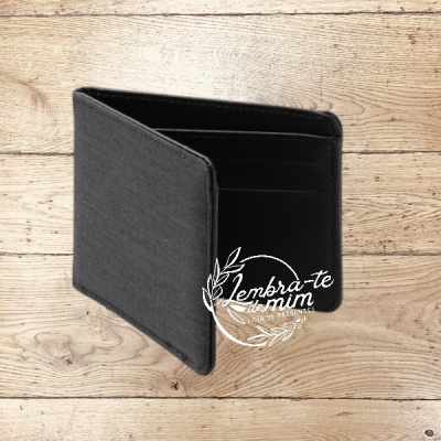 Carteira preta em tecido sobre superfície de madeira clara