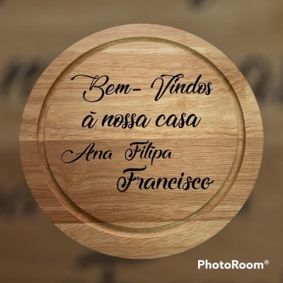 Tabuleiro redondo de madeira com gravação preta de boas-vindas em português.