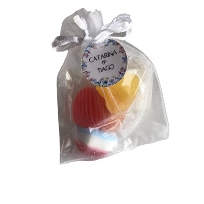 Saco de organza branco com bombons coloridos e etiqueta com os nomes Catarina & Tiago