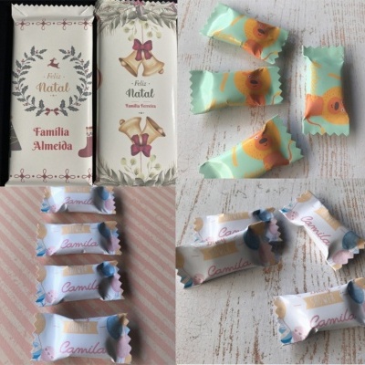 Vários doces embalados individualmente, incluindo barras de chocolate com tema natalício e doces com nomes personalizados.