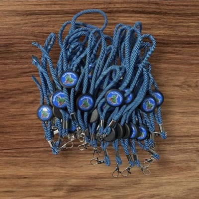 Cordões de nylon azul com botões redondos azuis e verdes sobre madeira clara