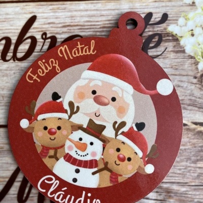 Etiqueta redonda de Natal com Pai Natal, boneco de neve e renas, texto 'Feliz Natal' e 'Cláudio'