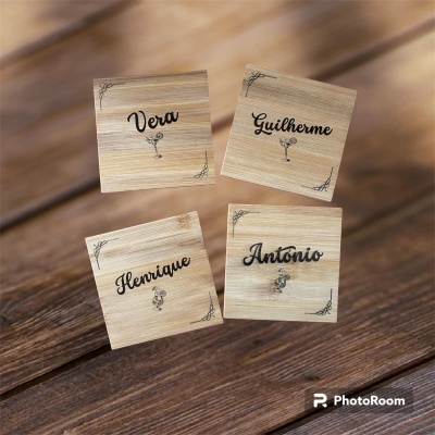 Peças de madeira clara com nomes escritos em preto sobre superfície de madeira escura