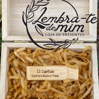 Caixa de madeira clara com tábua de madeira gravada e papel decorativo dentro