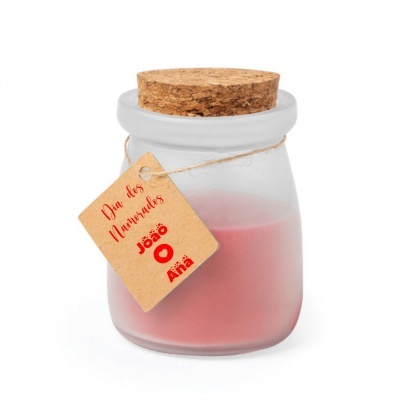 Vela rosa em frasco de vidro fosco com tampa de cortiça e etiqueta pendurada