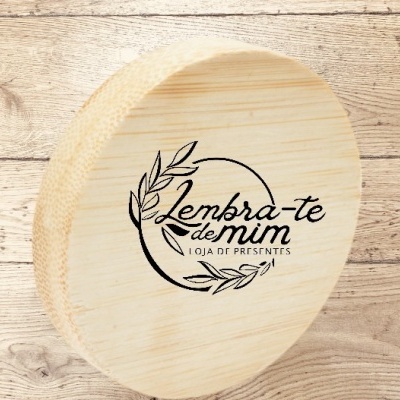 Caixa de madeira redonda com logótipo e texto em preto sobre tampa