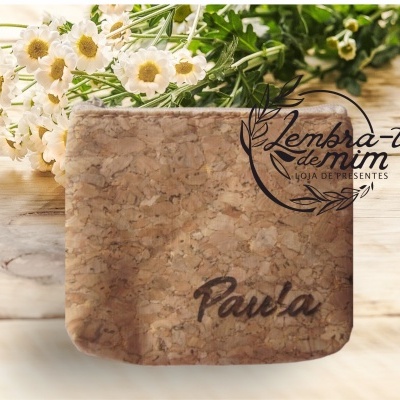 Porta-copos de cortiça com nome 'Paula' e flores brancas ao lado