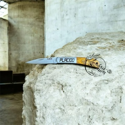 Faca de lâmina metálica com punho em madeira castanha clara com texto PLACIDO