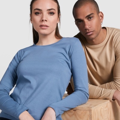 Modelos com t-shirts de manga comprida azul e bege, texto ausente, fundo neutro e cubo de madeira