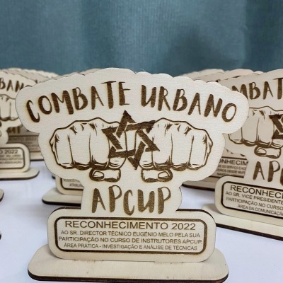Troféu de madeira gravado a laser com tema Combate Urbano APCUP e texto de reconhecimento em português