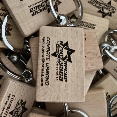 Chaveiros de madeira com argolas metálicas e texto preto sobrepostos