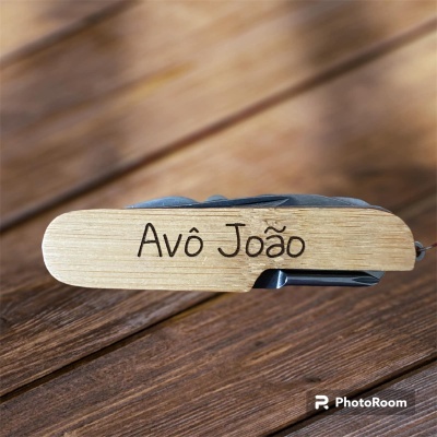 Canivete de madeira com gravação Avô João sobre superfície de madeira castanha