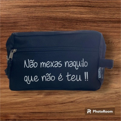 Estojo preto com frase em branco sobre mesa de madeira