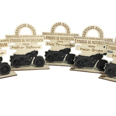Cinco prémios de madeira com desenhos e texto gravado relacionados com motorizadas