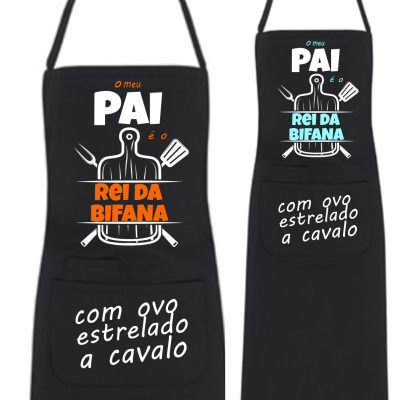 Dois aventais pretos com texto e ilustração relacionados a pai e bifanada em cores laranja e azul.