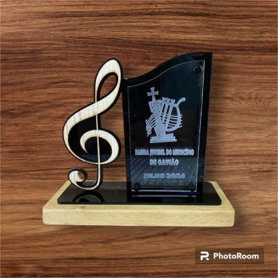 Troféu com clave de sol e placa acrílica preta gravada sobre base de madeira clara
