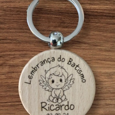 Chaveiro redondo em madeira clara com texto e desenho de anjo gravados