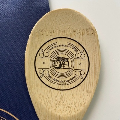 Colher de pau com gravação de texto e símbolo circular