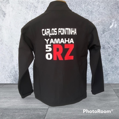 Casaco preto com texto branco e vermelho nas costas em fundo cinzento