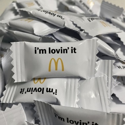 Pacotes brancos com texto 'i'm lovin' it' e logotipo McDonald's