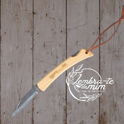 Colher de madeira clara com lâmina metálica e cordão de couro