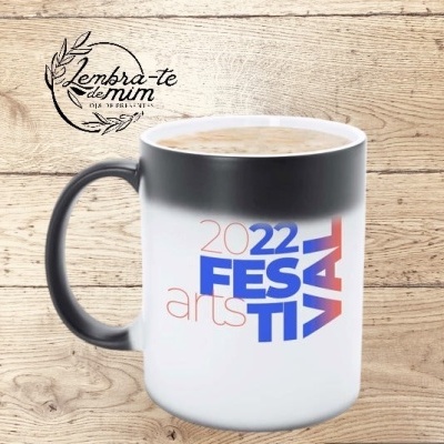 Caneca cerâmica preta e branca com texto '2022 FESTIVAL arts' e bebida cremosa