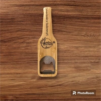 Abridor de garrafas em madeira clara com cabeça metálica e gravações a negro.