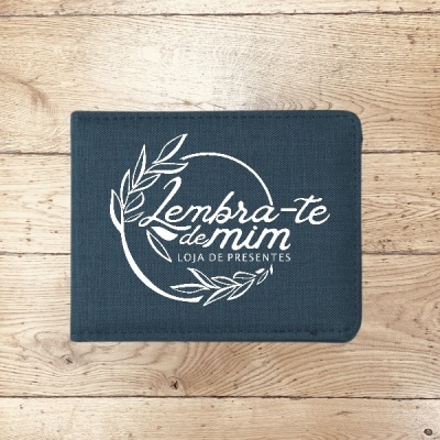 Carteira azul escura com bordado branco sobre superfície de madeira