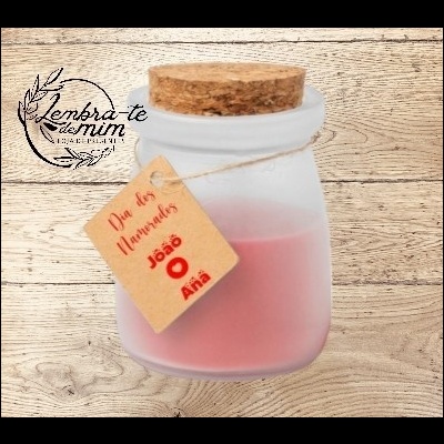 Vela rosa em frasco de vidro com tampa de cortiça e etiqueta pendurada