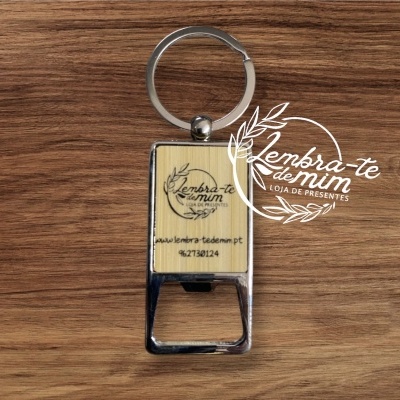 Chaveiro abre-garrafas em metal e madeira clara com texto gravado.