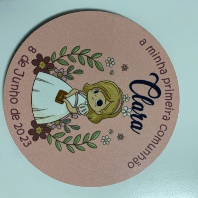 Círculo rosa com ilustração de menina em vestido branco e texto sobre primeira comunhão