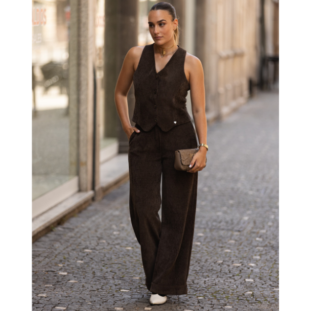 Colete feminino em bombazine castanho Miss You Mulher com colete e calças castanho escuro de tecido riscado numa rua de calçada