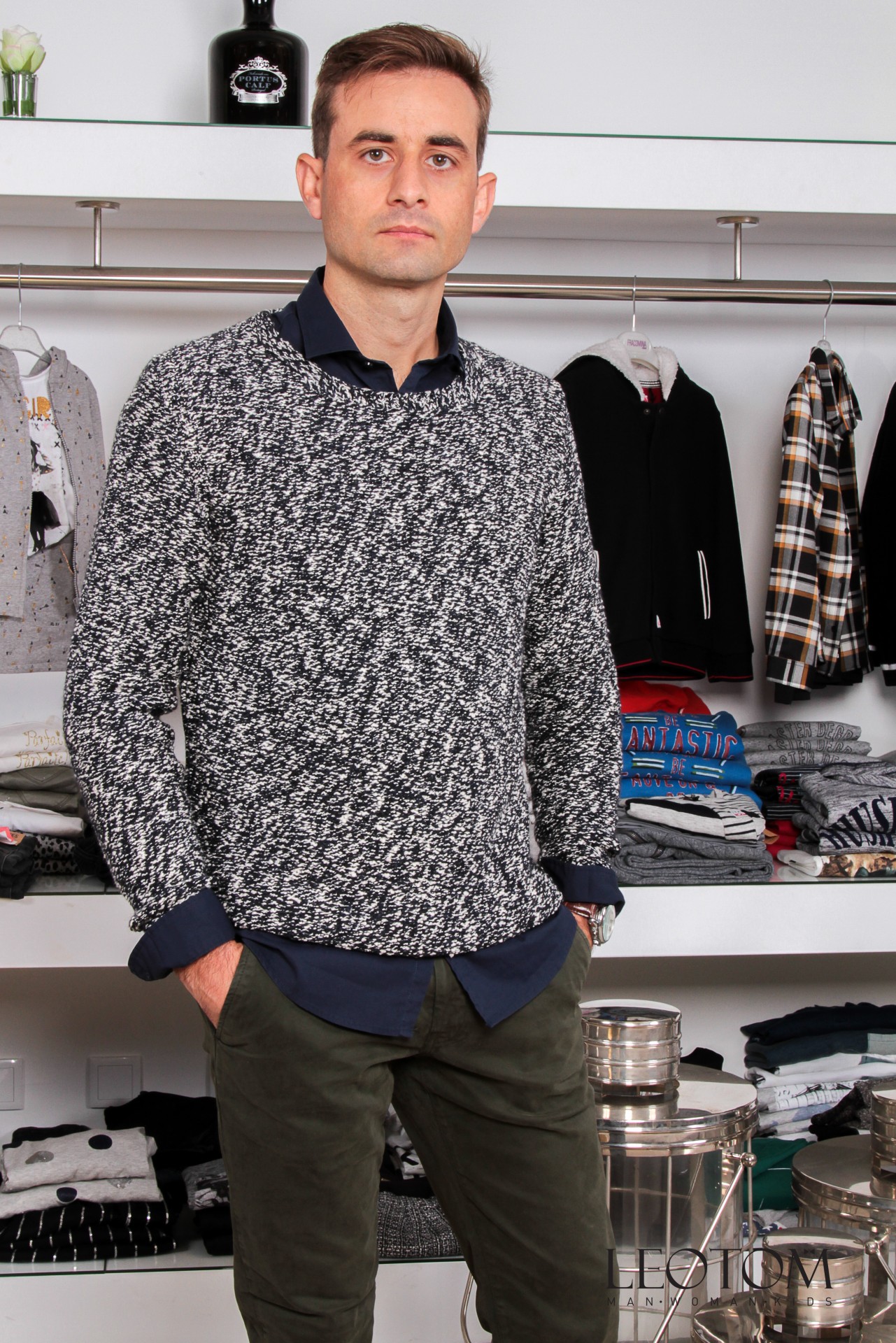 Camisola malha Individual Homem com camisola cinzenta e preta e camisa azul numa loja de roupas