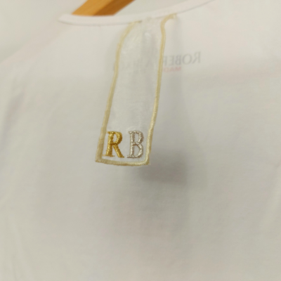 Camisola branca com etiqueta bordada e cabide de madeira