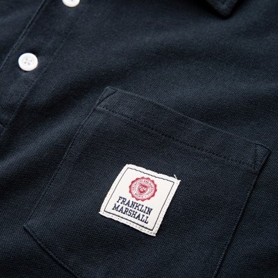 Polo preto com bolso frontal e etiqueta Franklin Marshall