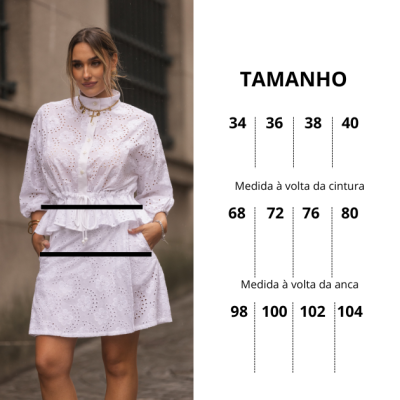 Vestido branco bordado com mangas longas e bolsos usado por mulher na rua