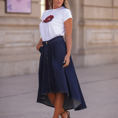 Mulher com t-shirt branca com estampa e saia de ganga azul