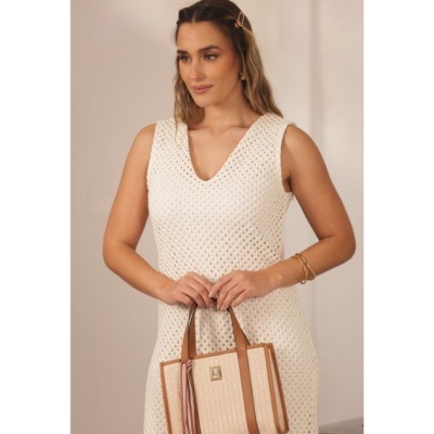 Mulher com vestido branco de malha e mala bege com alças castanhas