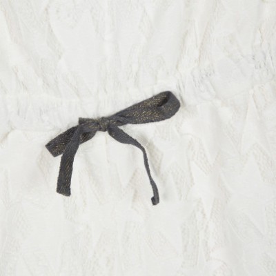 pormenor de roupa branca com fita preta brilhante em laço