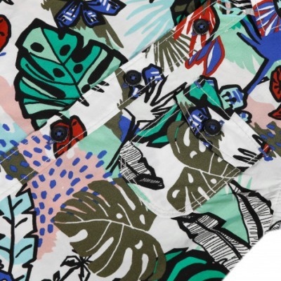 tecido estampado com folhas tropicais e botões pretos