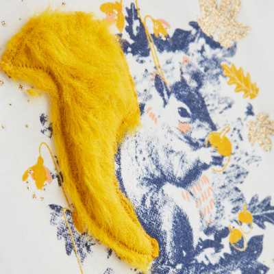 Estampa detalhada de esquilo em tecido branco com aplicação amarela e detalhes dourados