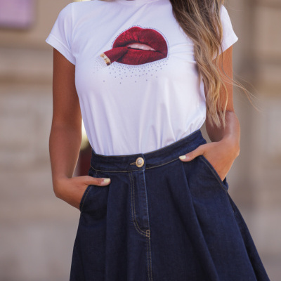 T-shirt branca com estampa de lábios vermelhos e saia azul escuro de denim