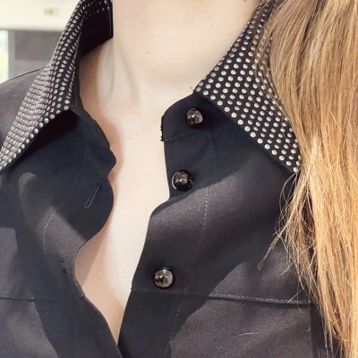 Camisa preta com botões e gola preta com padrão de círculos brancos