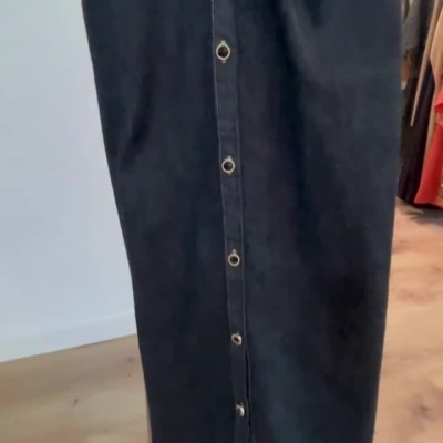 Vestido escuro tipo ganga com botões frontais dourados e colarinho em cabide.