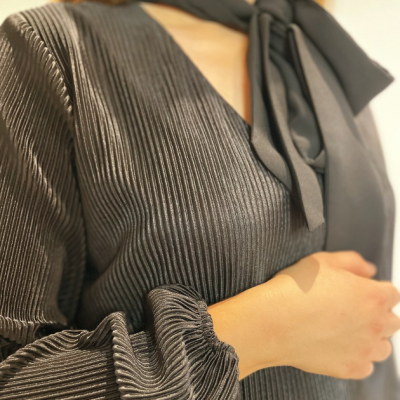 Blusa feminina cinza texturizada com laço preto no pescoço